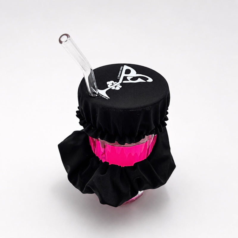 Vue de dessus du chouchou anti-drogue Protect Your Glass déployé sur un verre avec paille.