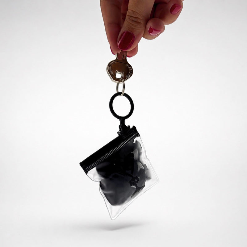 Estuche llavero Protect Your Glass con el protector de vaso guardado, enganchado a un juego de llaves.