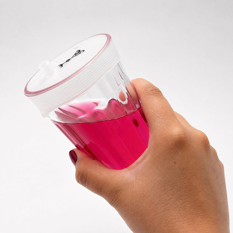 Verre équipé d'une capote en silicone Protect Your Glass tenu en main.