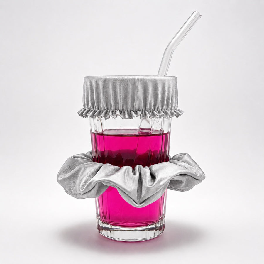 Chouchou anti-drogue argent Protect Your Glass déployé sur un verre avec paille.