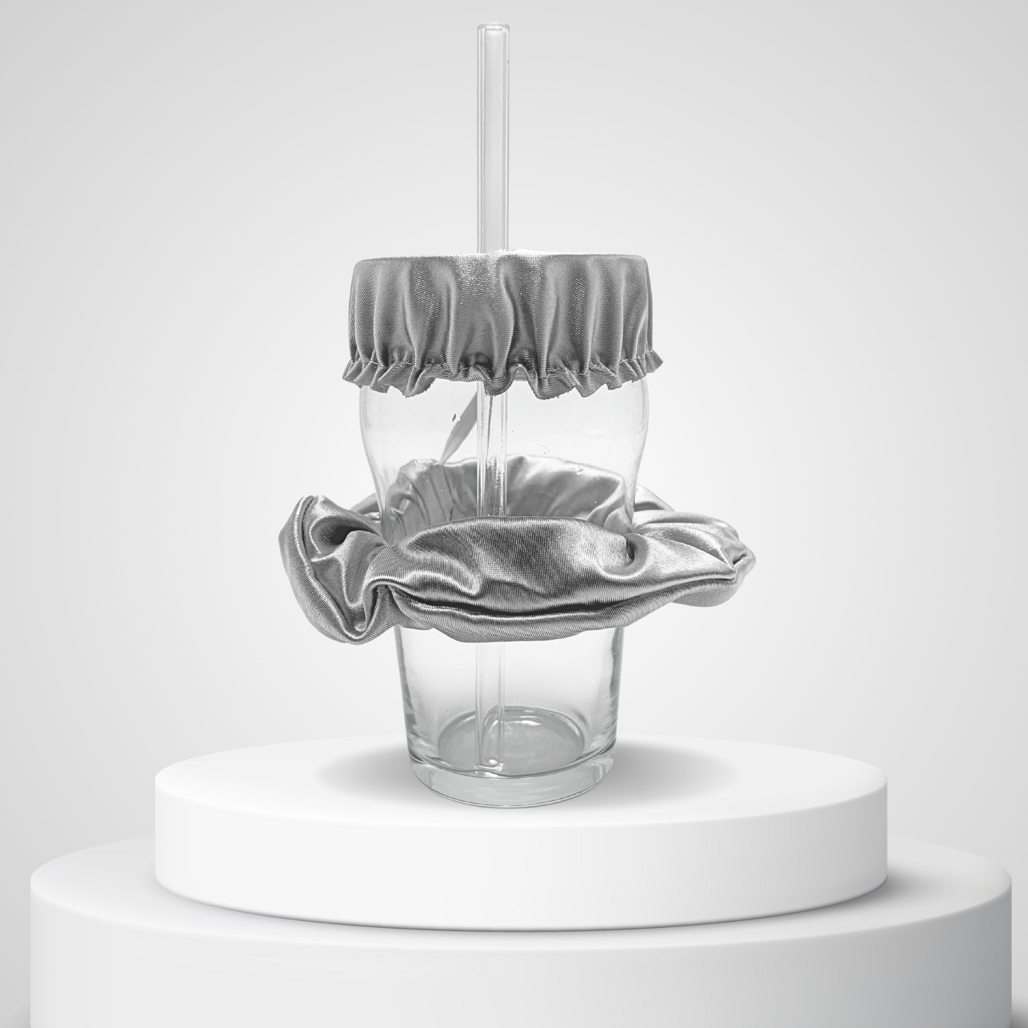 Chouchou anti-drogue argenté Protect Your Glass présenté sur un podium en studio