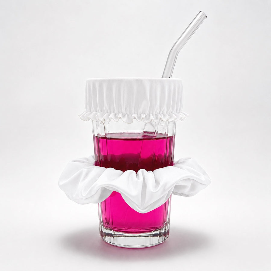 Chouchou anti-drogue rose bonbon Protect Your Glass déployé sur un verre avec paille.