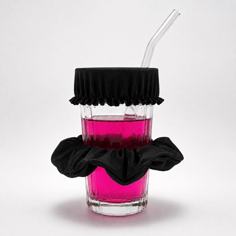 Chouchou anti-drogue noir Protect Your Glass déployé sur un verre avec paille.
