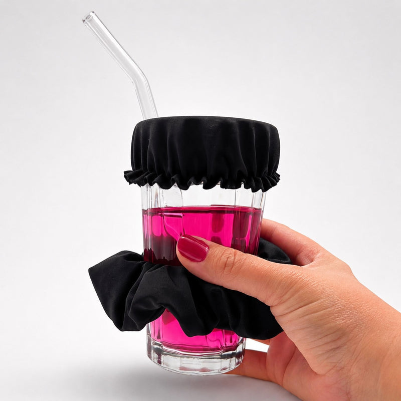 Verre protégé par le chouchou anti-drogue Protect Your Glass tenu en main.