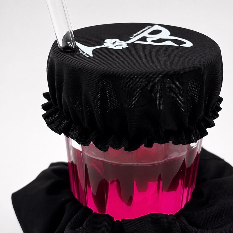 Chouchou anti-drogue Protect Your Glass utilisé comme protection sur un verre avec paille.