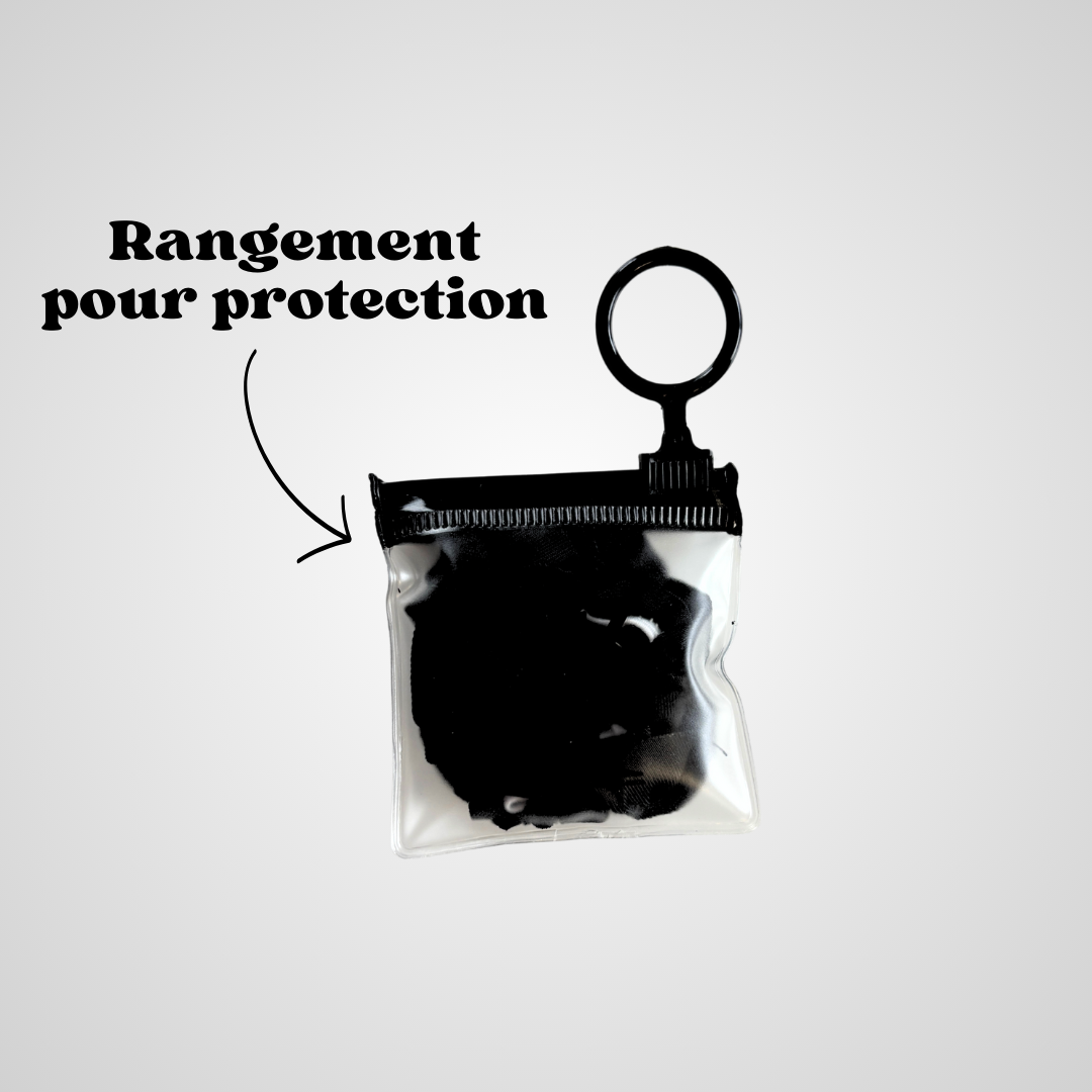 Gros plan sur un étui transparent contenant un protège-verre en tissu noir, équipé d’un anneau porte-clés