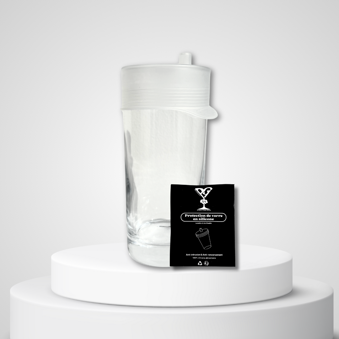 Protection de verre en silicone alimentaire blanc avec tétine, présentée sur un verre aux côtés de son emballage noir réutilisable